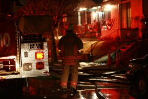 Capt. Mike Auteri of BDFD (before he was Chief) at fire scene in Dayton with a fire engine and red lights on a row of houses