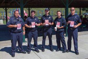 Five BDFD firefighters standing looking at camera holding "NKY Hates Heroin" flyers