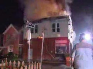 Apartment/business fire with smoke rising from roof