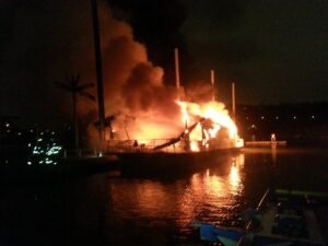 Large boat fire in Manhattan Harbor, Ky. Flames and smoke rising from a burning boat over the water
