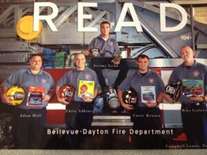 BDFD officers posed for a poster encouraging reading in children. "READ" is across the top