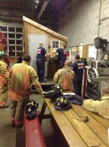 Fire department training with multiple firefighters and props inside